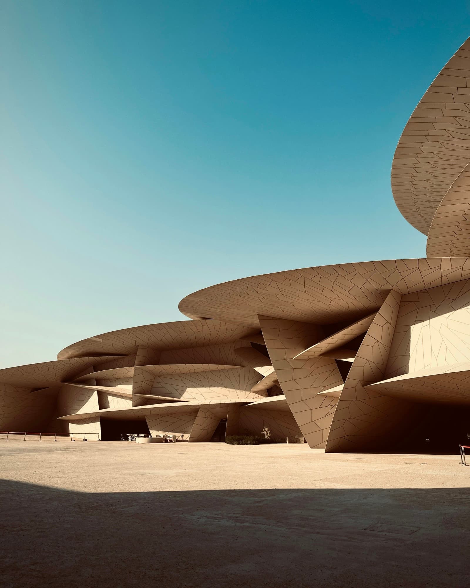 The interlocking disc facade of the National Museum of Qatar catching desert light in Doha.