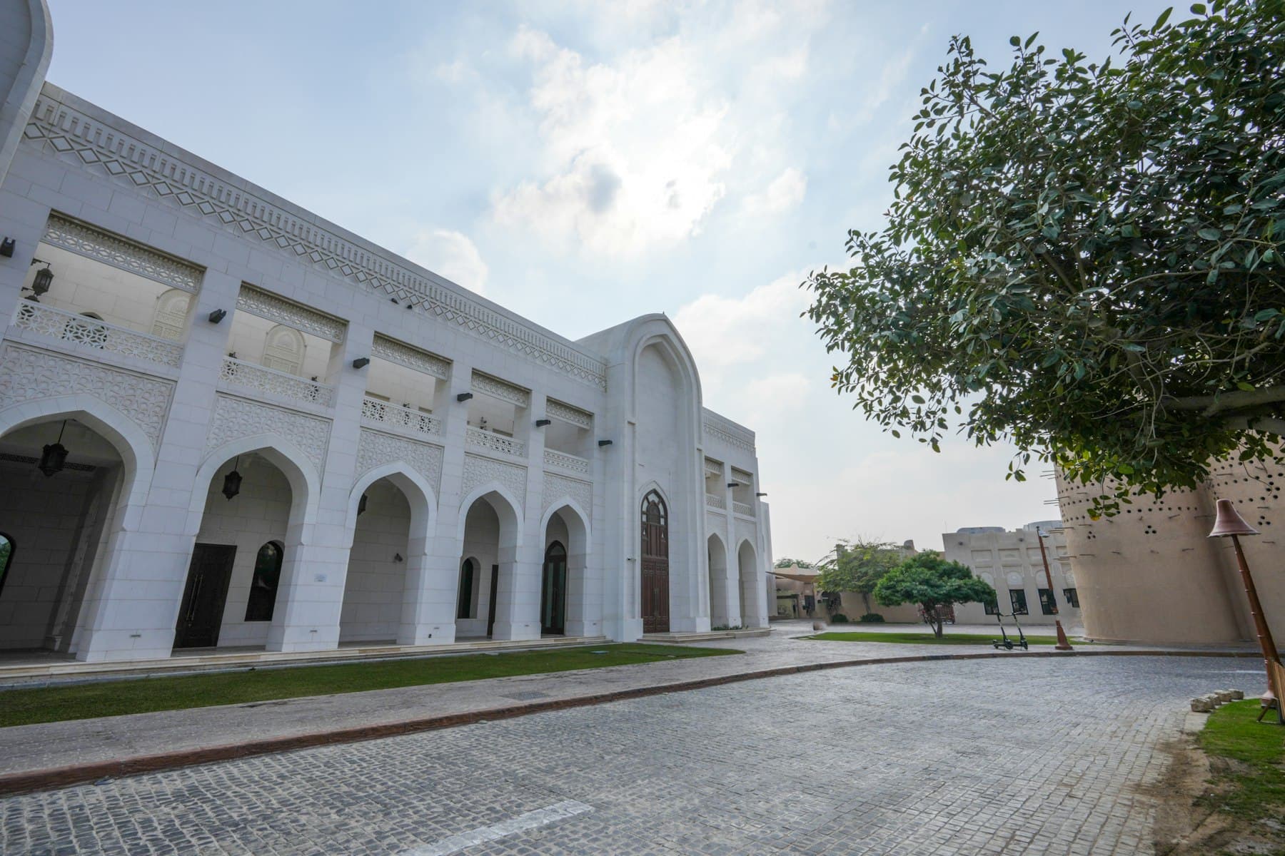 A white contemporary building at Katara Cultural Village in Doha under clear sky.