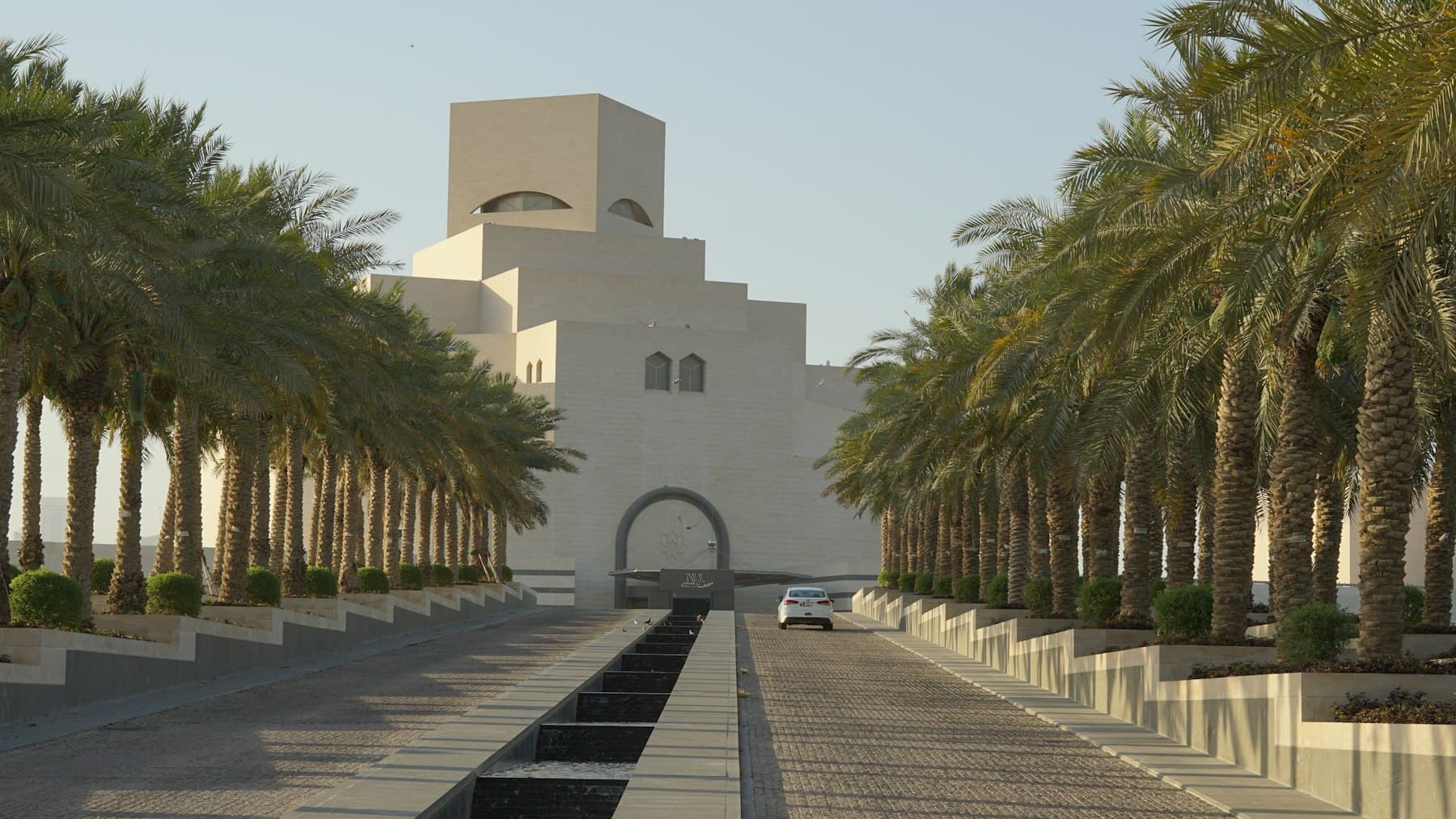 The Museum of Islamic Art in Doha, its geometric limestone tiers rising above the water.